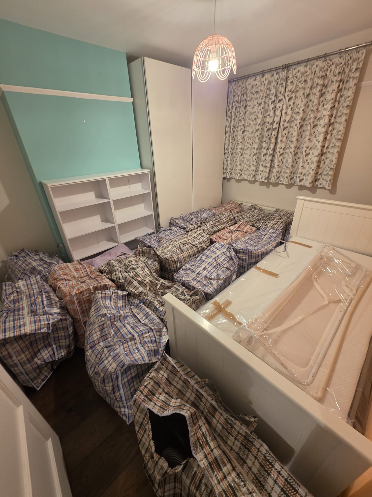 Packed belongings and dismantled furniture in a bedroom